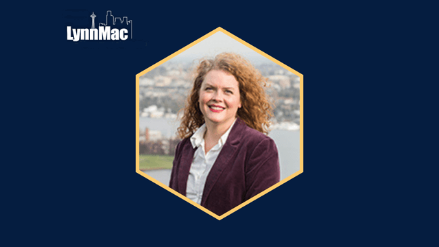 Smiling woman in a hexagon frame with a cityscape background, "LynnMac" logo above.